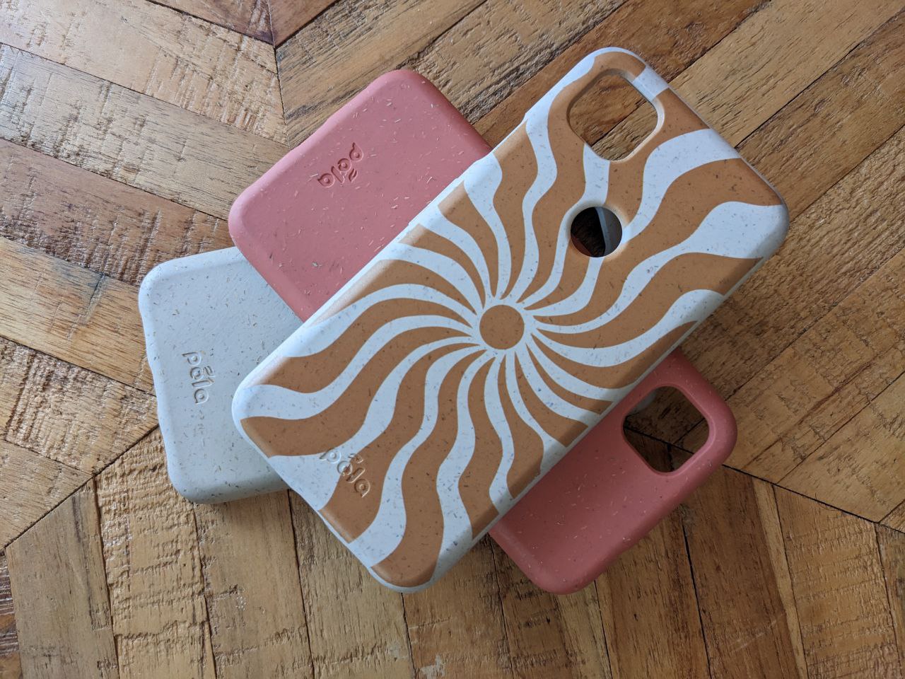 Pela compostable phone cases on a wooden floor